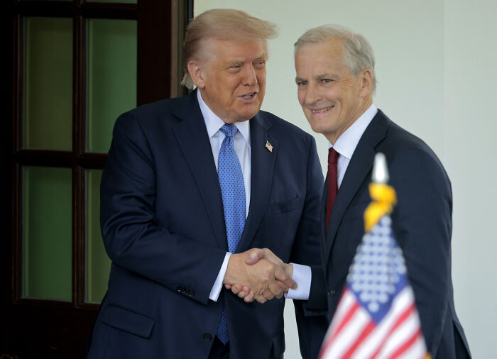 Donald Trump shaking hands with a man in a suit, relating to his statement on peace in a disturbing letter.