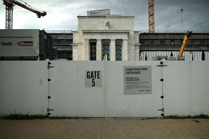 Construction site fence blocking view of a federal building under renovation, representing Fed Chair Jerome Powell investigation context.