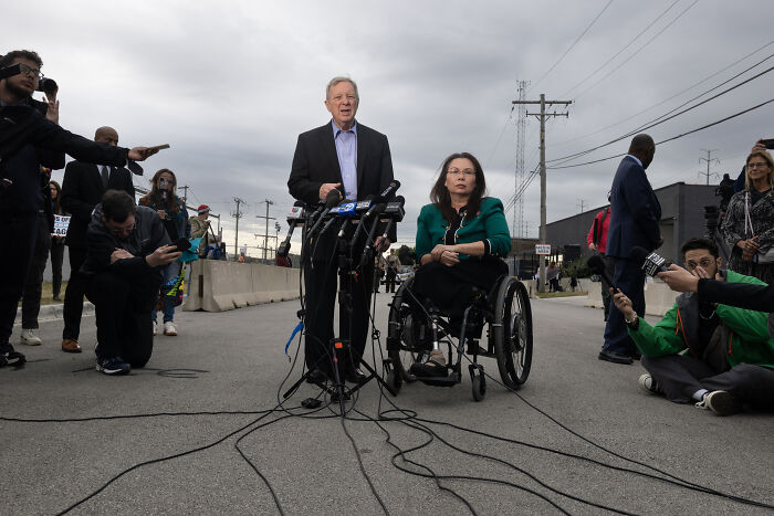 Politician speaking at outdoor press event next to a woman in a wheelchair amid controversy involving JD Vance and combat veteran. Politician speaking at outdoor press event next to a woman in a wheelchair amid controversy involving JD Vance and combat veteran.