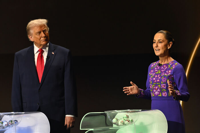 Donald Trump and a woman in a purple dress at a formal event, discussing political topics with a dark background.