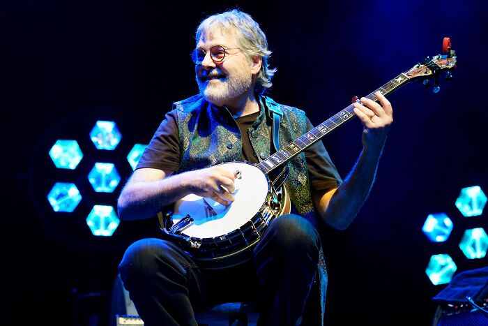 Musician playing banjo on stage with blue lighting, related to Kennedy Center President and 18-Time Grammy winner cancelation.