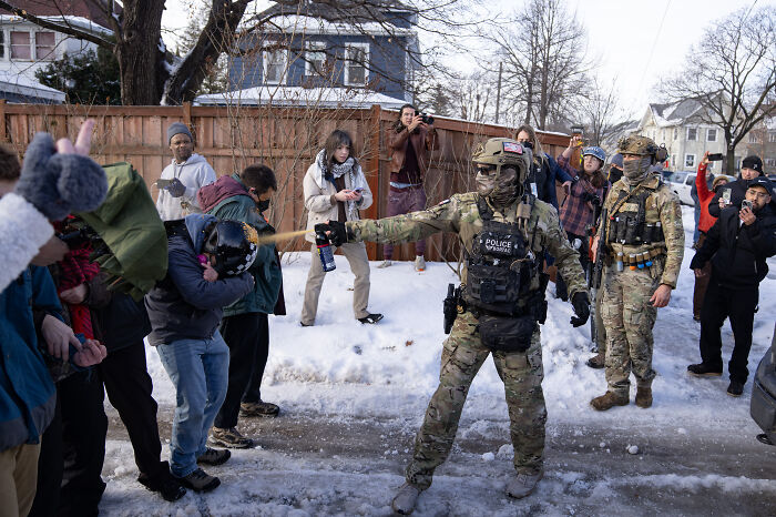 Police in tactical gear using pepper spray to disperse protesters near snowy Minneapolis streets, relating to Renee Good’s training disruption. Police in tactical gear using pepper spray to disperse protesters near snowy Minneapolis streets, relating to Renee Good’s training disruption.