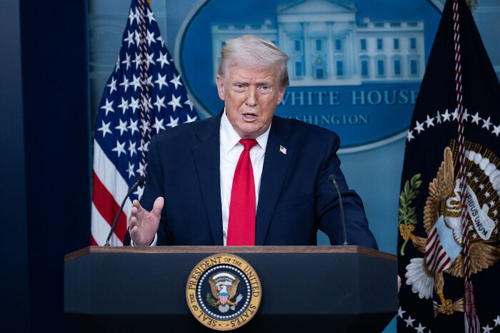 Former U.S. president speaking at White House podium with flags, related to Greenland trolls viral urban yoga video topic. Former U.S. president speaking at White House podium with flags, related to Greenland trolls viral urban yoga video topic.