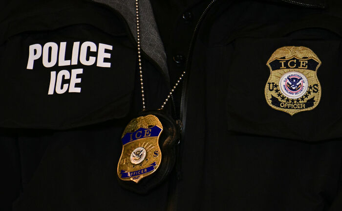 Close-up of ICE officer badge and uniform details highlighting ICE police role in detaining 5-year-old boy incident