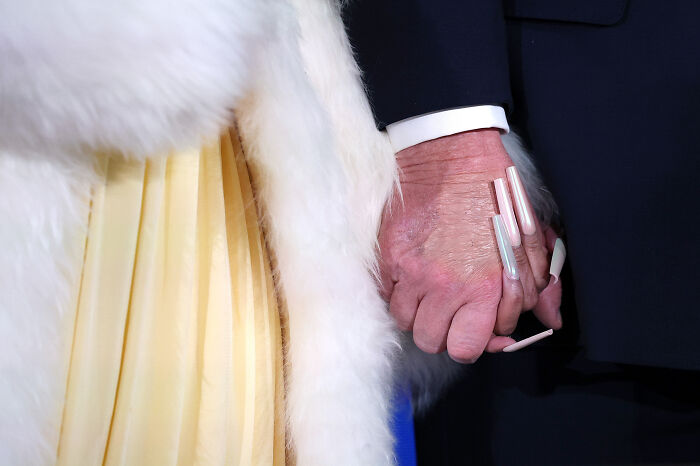 Close-up of hands holding, featuring long acrylic nails and a white fur coat, related to Nicki Minaj MAGA and Trump discussion. Close-up of hands holding, featuring long acrylic nails and a white fur coat, related to Nicki Minaj MAGA and Trump discussion.