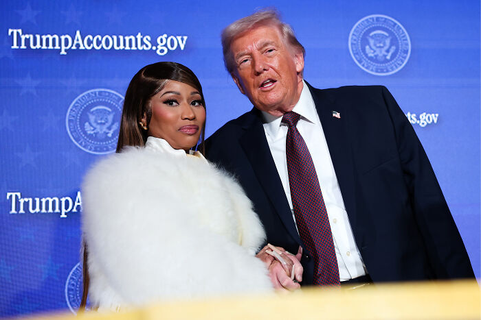 Nicki Minaj and Donald Trump posing together at an event with TrumpAccounts.gov signs in the background. Nicki Minaj and Donald Trump posing together at an event with TrumpAccounts.gov signs in the background.