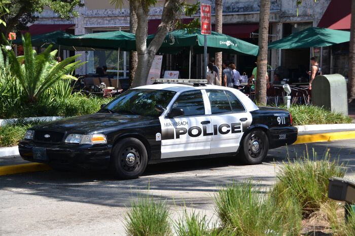 Miami Beach police car parked near outdoor cafe, linked to free-speech controversy involving Facebook comment inquiry. Miami Beach police car parked near outdoor cafe, linked to free-speech controversy involving Facebook comment inquiry.