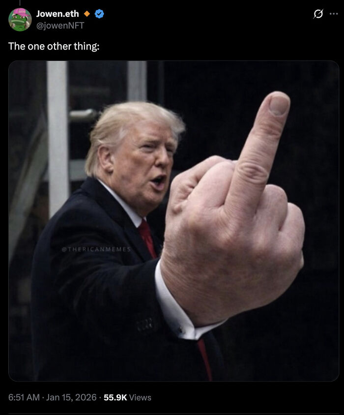 Former president giving a large middle finger gesture in a dark suit with a red tie, captured in a public setting.