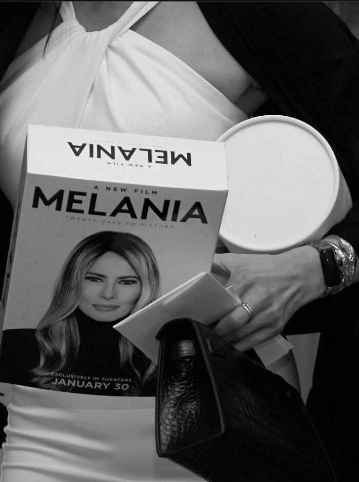 Person holding a Melania Trump documentary box and other items during a gaudy documentary screening event. Person holding a Melania Trump documentary box and other items during a gaudy documentary screening event.