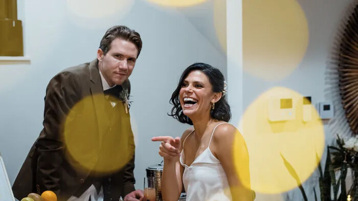 Slain Ohio couple laughing at a wedding reception with warm bokeh lights in the foreground Slain Ohio couple laughing at a wedding reception with warm bokeh lights in the foreground