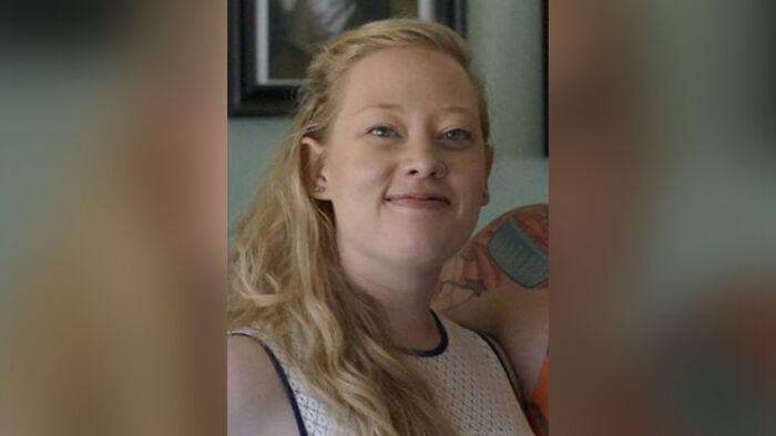 Woman with long blonde hair smiling, wearing a white sleeveless top, related to Minnesota ICE slaying discussion.