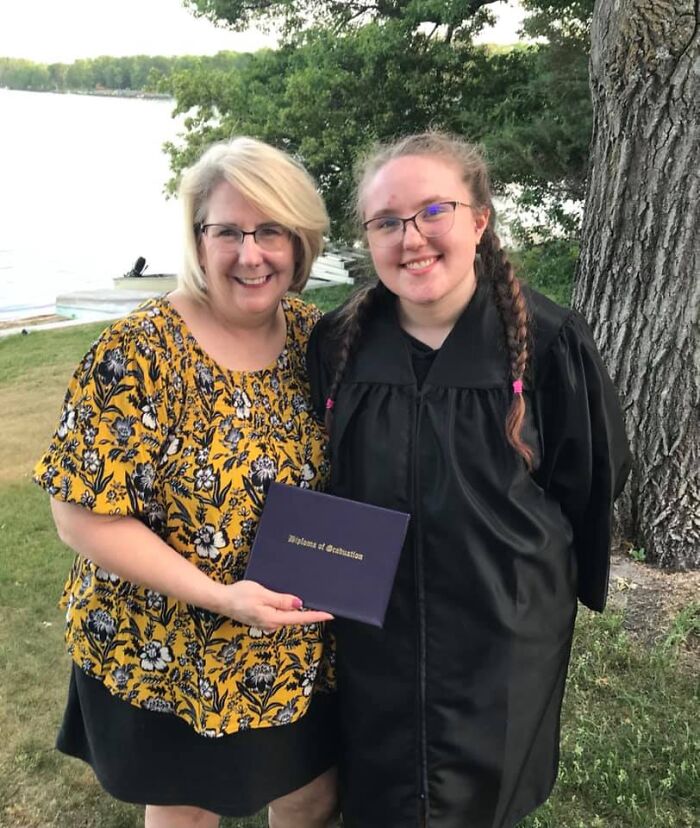 Minnesota gubernatorial candidate with daughter in graduation gown, outdoors by lake, highlighting family and campaign pause news.