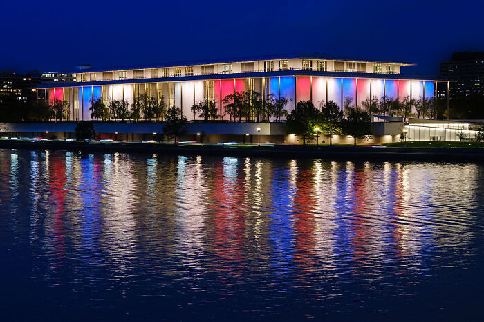 Kennedy Center illuminated at night with red, white, and blue lights reflecting on water before planned 2-year renovation closure. Kennedy Center illuminated at night with red, white, and blue lights reflecting on water before planned 2-year renovation closure.