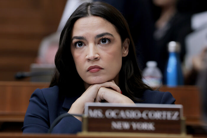 Alexandria Ocasio-Cortez in a navy blazer, focused and thoughtful, signaling potential 2028 White House run. Alexandria Ocasio-Cortez in a navy blazer, focused and thoughtful, signaling potential 2028 White House run.