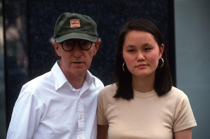 Woody Allen with his wife, both looking at the camera, related to Epstein emails and #MeToo criticism context.