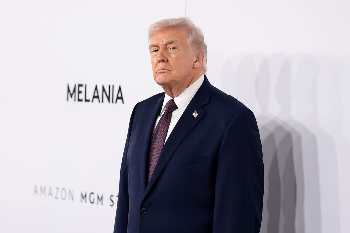 Donald Trump in a dark suit and tie at an event, related to Kennedy Center closure and renovation announcement. Donald Trump in a dark suit and tie at an event, related to Kennedy Center closure and renovation announcement.