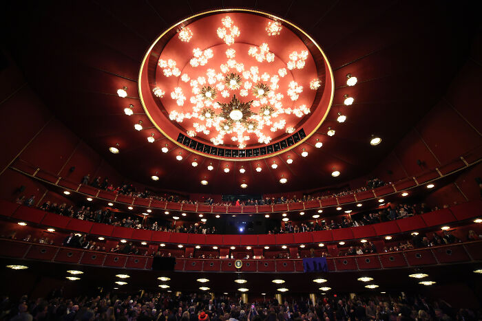 Interior view of the Kennedy Center with a large chandelier and audience seating before renovation announcement. Interior view of the Kennedy Center with a large chandelier and audience seating before renovation announcement.