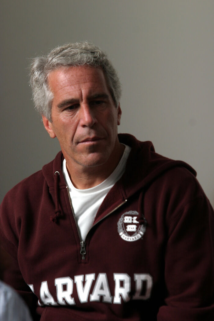 Jeffrey Epstein wearing a maroon Harvard hoodie in a serious moment, related to resuscitation efforts after being found in his cell