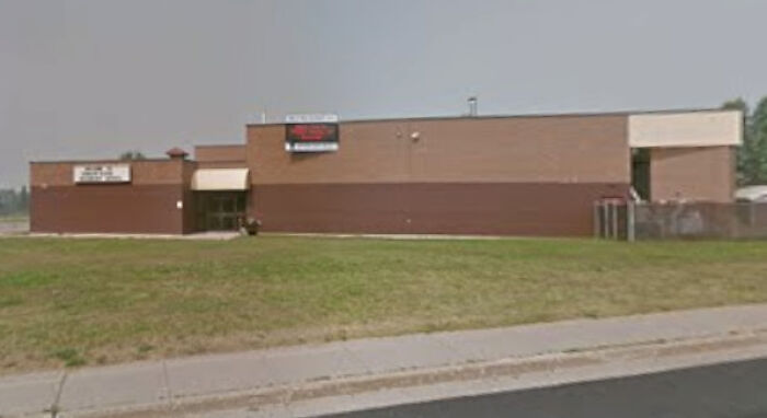 School building in British Columbia with empty lawn, related to Canadian Prime Minister reacting after B.C. school attack incident.