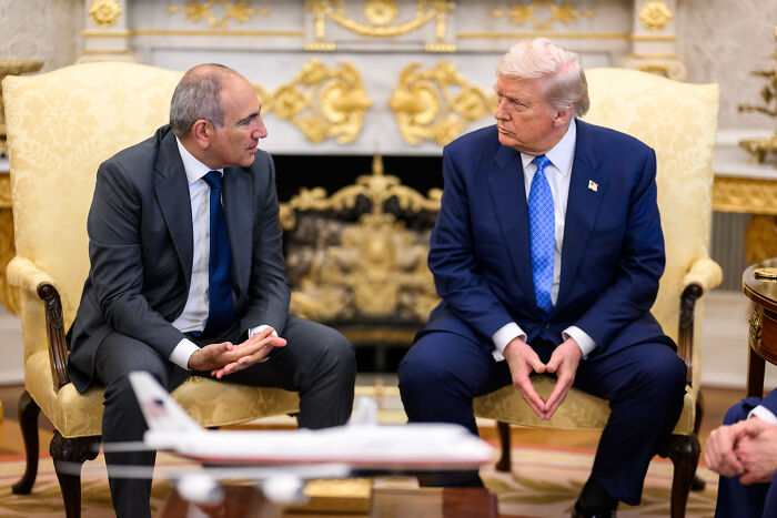 Two men in formal suits having a serious discussion in a luxurious room, related to JD Vance Armenia post deletion.